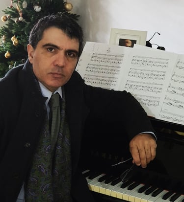 a man in a suit and tie is sitting at a piano