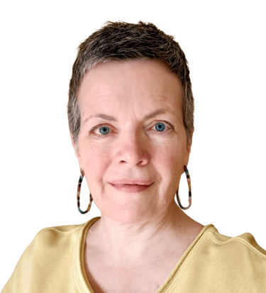 Head & shoulders photo of middle aged woman with short greying hair and blue eyes