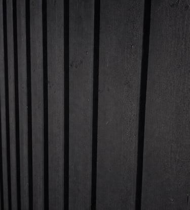 Matte black exterior wood siding finished with breathable heritage paint