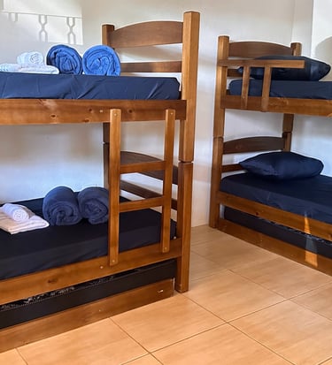 Camas confortáveis e ambiente tranquilo na Pousada Santa Júlia, ideal para peregrinos na Rota da Luz