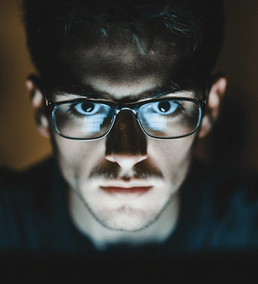a man in glasses and glasses looking at a laptop