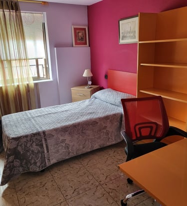Cama, ventana y escritorio de la habitación