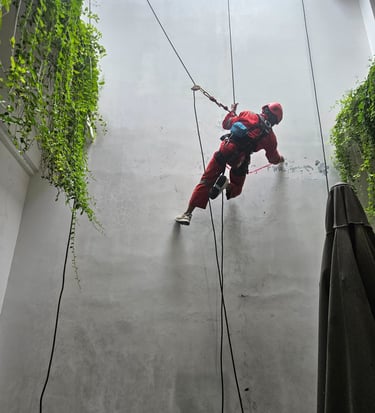 a man in a red suit is climbing on a rope