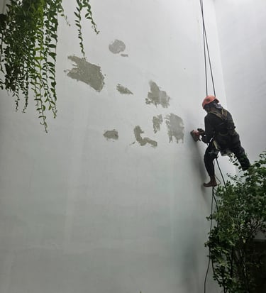 a man climbing up a wall with a rope