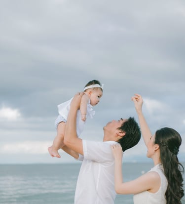 Father lifting baby near the ocean during family photography session at Sofitel Nusa Dua Bali