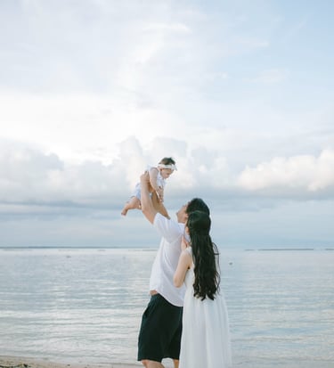 Mother holding child by the beach during family photography session at Sofitel Nusa Dua Bali