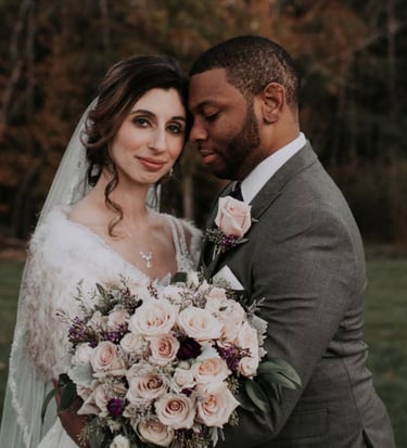 Bride and groom with beautiful pink rose bouquet, and stunning wedding hair and wedding makeup