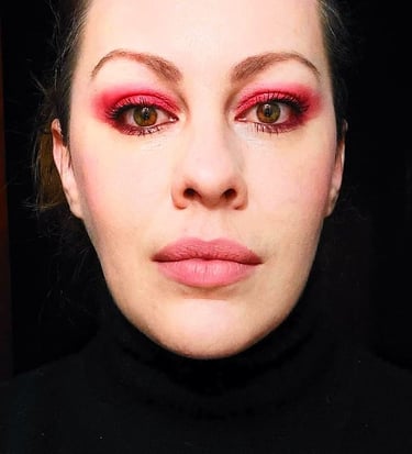 a woman with a red eye makeup and pink eye makeup