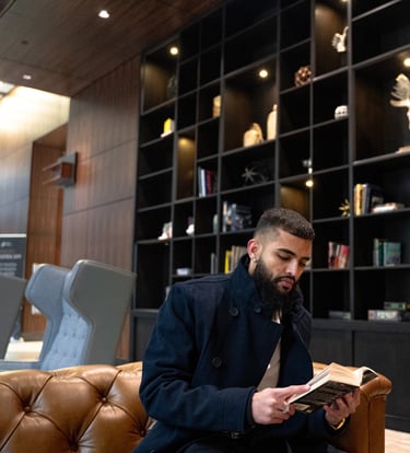 a man sitting on a couch reading a book Mohit Dhillon
