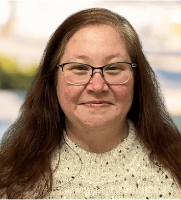 a woman with glasses and a sweater on