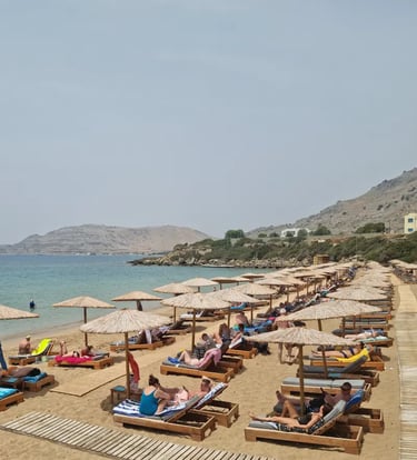 a beach with many people sitting on lounge chairs