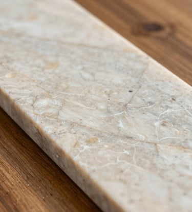 Macro photography of premium interior materials in a South American / Brazilian style, showcasing the texture of polished light quartzite and warm wood. Professional studio lighting emphasizes the refined craftsmanship and off-white and greige color palette.