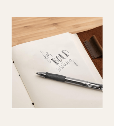 picture of a black bic pen on a open notebook with "for bold writing" written on page
