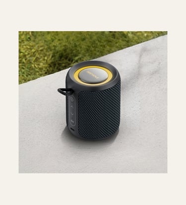 Portable Deeyaple Bluetooth speaker in black mesh with yellow accents on a stone surface.