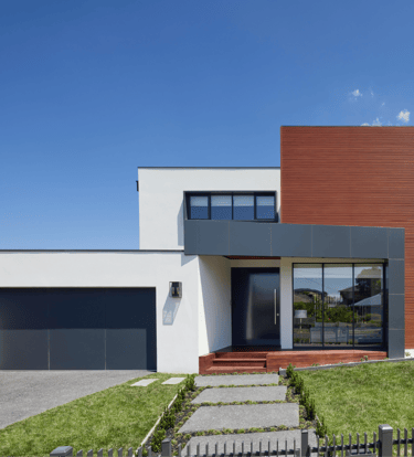 Una casa de construcción en seco con entrada para autos y área cercada.