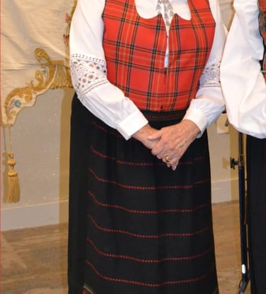 a woman in a red plaid festdrakt with a solje