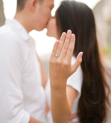 Couple kissing while showing engagement ring during proposal at Melasti Beach Bali  