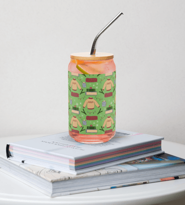 a glass tumbler with a pattern with a sweater blanket and stack of books