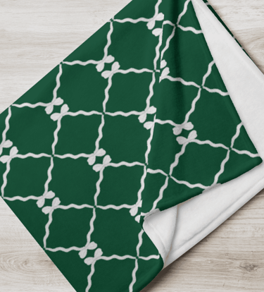 a green and white patterned blanket with bows and ribbon