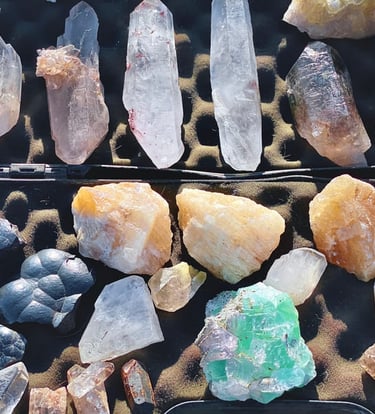 Una colección de cristales curativos crudos que incluye puntas de cuarzo transparente, citrino y flu