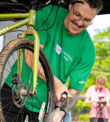 A Local Motion volunteer hosing off a dirty bike
