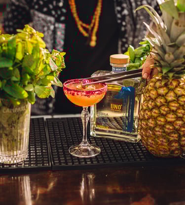 tequila cocktail fruityon a bar with a bottle of uno tequila reposado - premium tequila reposado