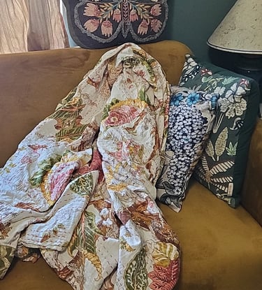 Pink floral kantha quilt on sofa
