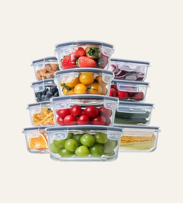Stacked glass food storage containers with airtight lids filled with fresh fruits and vegetables.