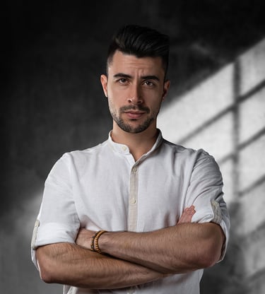 Studiový portrét modela pózujícího před pozadím starého krásně osvíceného výrobního prostoru.