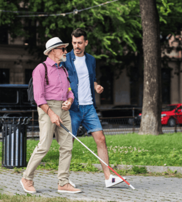 Man with macular degeneration and cane for the blind traveling in a big city