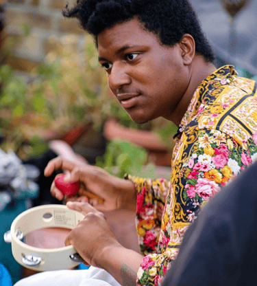 ryan morgan - man in colourful shirt playing the egg shaker