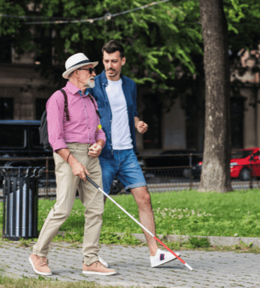 Man with macular degeneration and cane for the blind traveling in a big city