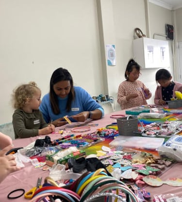 Niñas pequeñas y una maestra disfrutan de un taller creativo