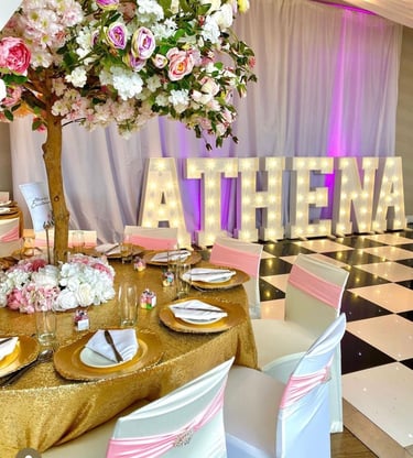 Elegant party reception table with gold sequins, cherry blossom tree centerpieces, and light-up marquee letters.
