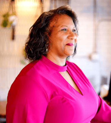 Pastor Dezi Epps Berry in pink dress and smiling brightly