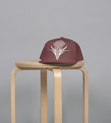 a brown hat with a rice flower on it sitting on a stool