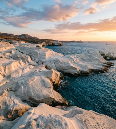 Sarakiniko white volcanic rock formations meeting turquoise Aegean Sea in Milos at sunset