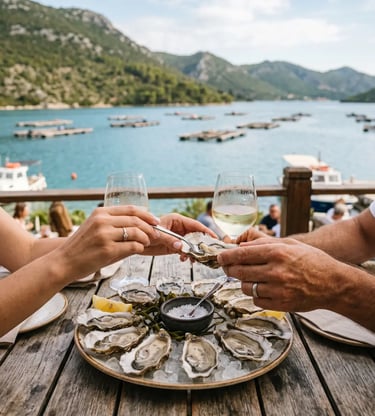 Couple toasting with oysters and white wine above Mali Ston Bay oyster farms, Croatia