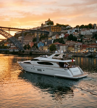 White luxury yacht cruising Douro River at sunset with Porto Ribeira skyline and Dom Luís Bridge.
