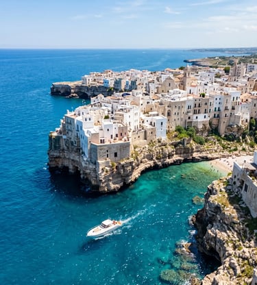 Aerial view of Polignano a Mare white clifftop town with private boat on turquoise sea