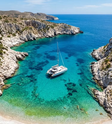 Aerial view of luxury catamaran anchored in Polyegos turquoise cove near Milos, Greece 