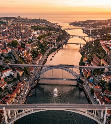 Aerial drone view of Porto six bridges over Douro River with yacht at golden hour