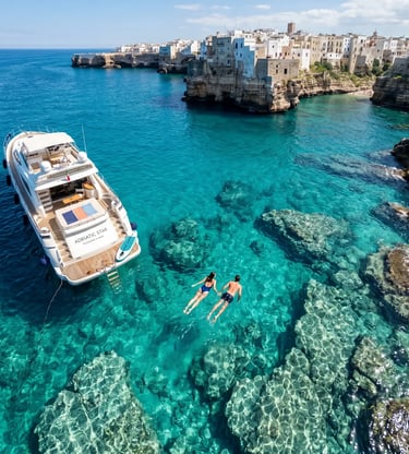 Couple swimming beside luxury private yacht in turquoise water near Polignano a Mare, Puglia