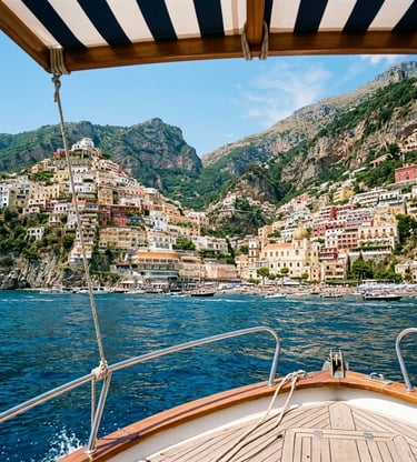 Approaching Positano by boat under striped canopy with colorful hillside village ahead
