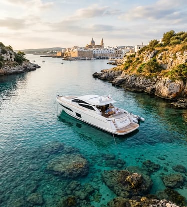 Aerial view of white private yacht Aurora anchored in turquoise cove near Monopoli old town