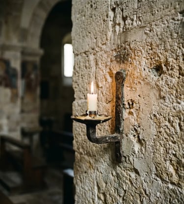 Single candle burning on iron wall mount against rough limestone church wall Italy