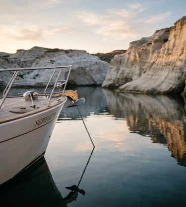 Bow of luxury yacht anchored in calm volcanic cove at sunset in Milos Greece