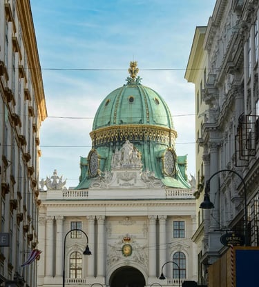 Vienna Hofburg Palace green dome framed between buildings on a sunny day