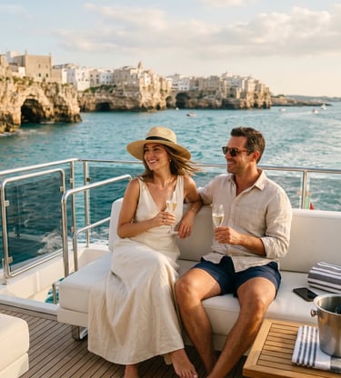 Elegant couple sipping prosecco on yacht deck overlooking Polignano a Mare cliffs at golden hour