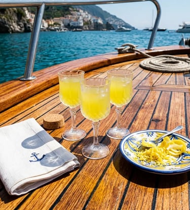 Three limoncello glasses and lemon zest plate on teak deck of Capri boat tour from Sorrento